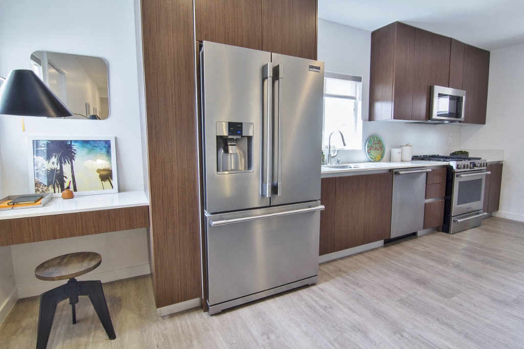 a living room with a gray couch and a kitchen in the background